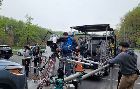 A man sits against a rock wall inside a dimly lit cave